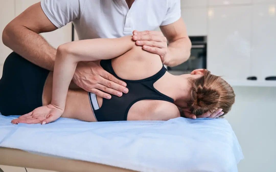 A physiotherapist mobilising a patient's shoulder by hand
